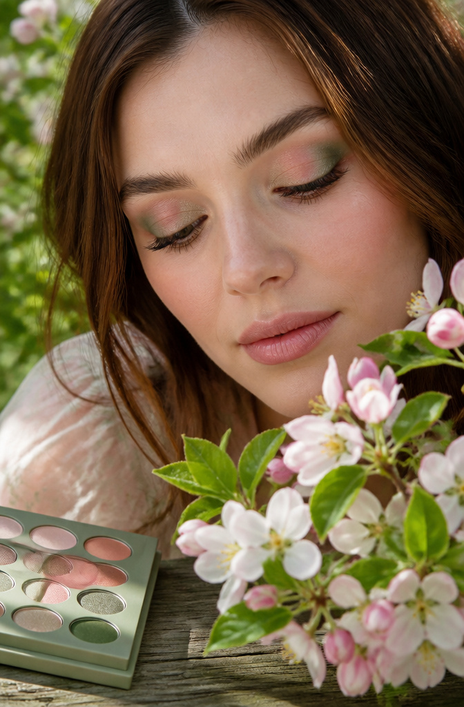 A model with soft eyeshadow in muted sage and dusty rose hues.