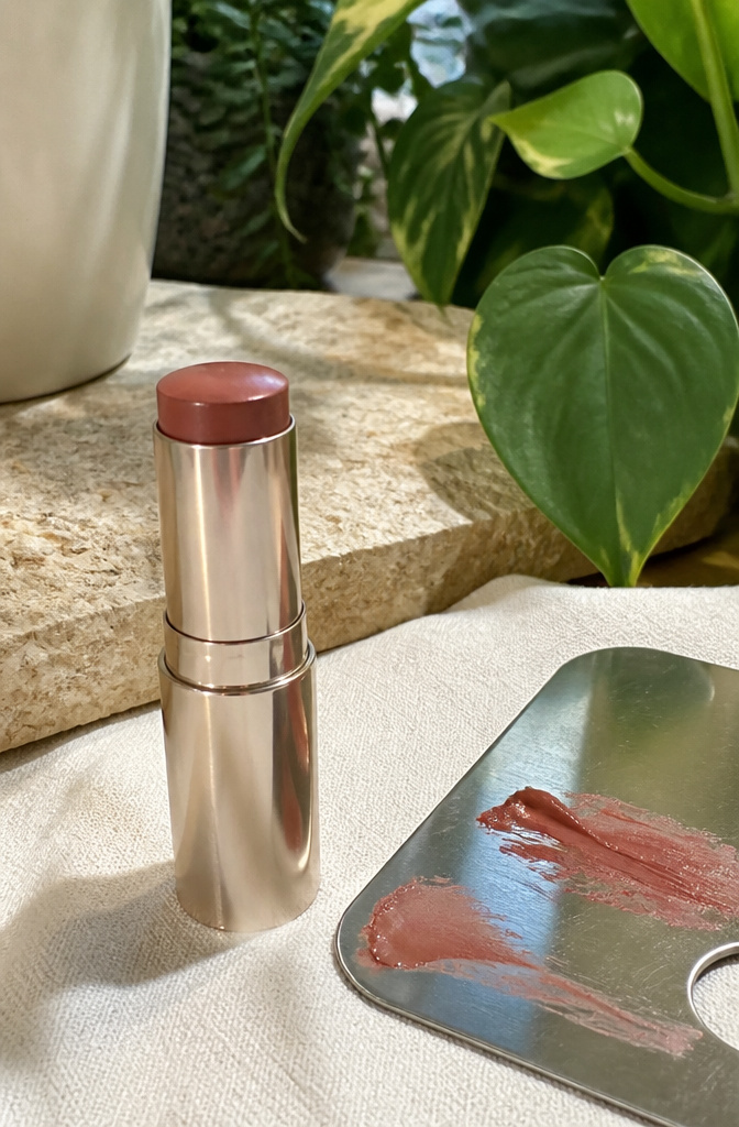 Brown Blush Makeup: 20 Best Picks for 2026 4 Haus Labs Color Fuse Glassy Blush Balm Stick in Clove against a stone background.