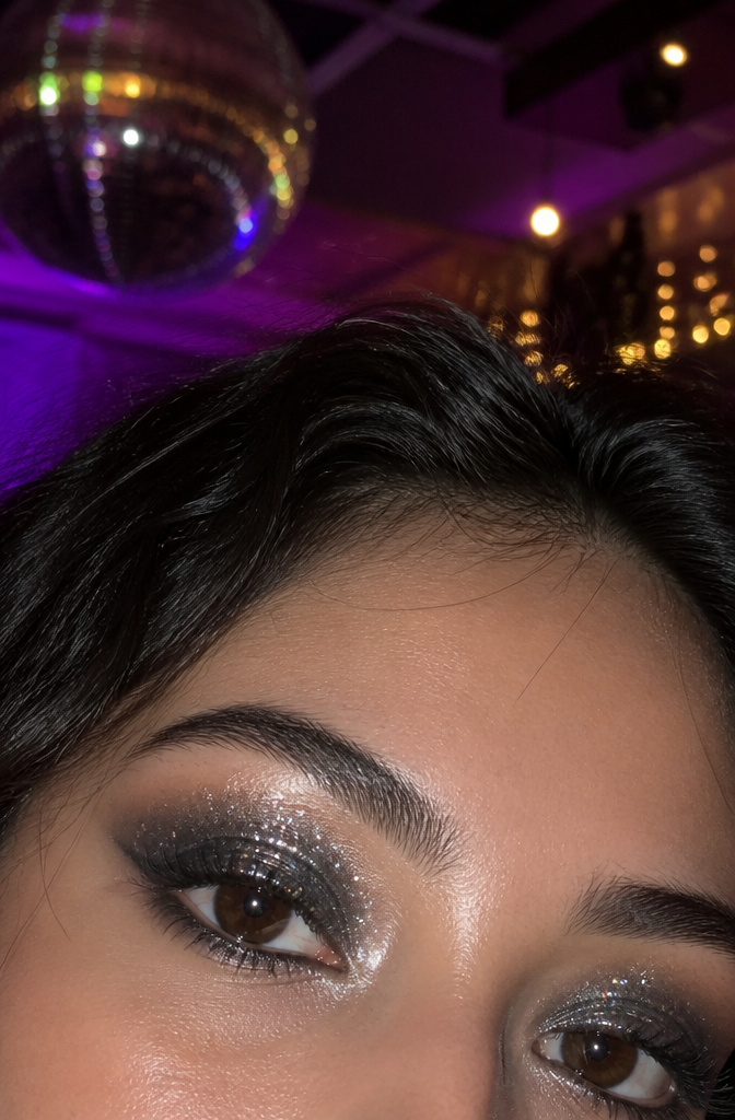Model with loose glitter eyeshadow applied to her eyelids.
