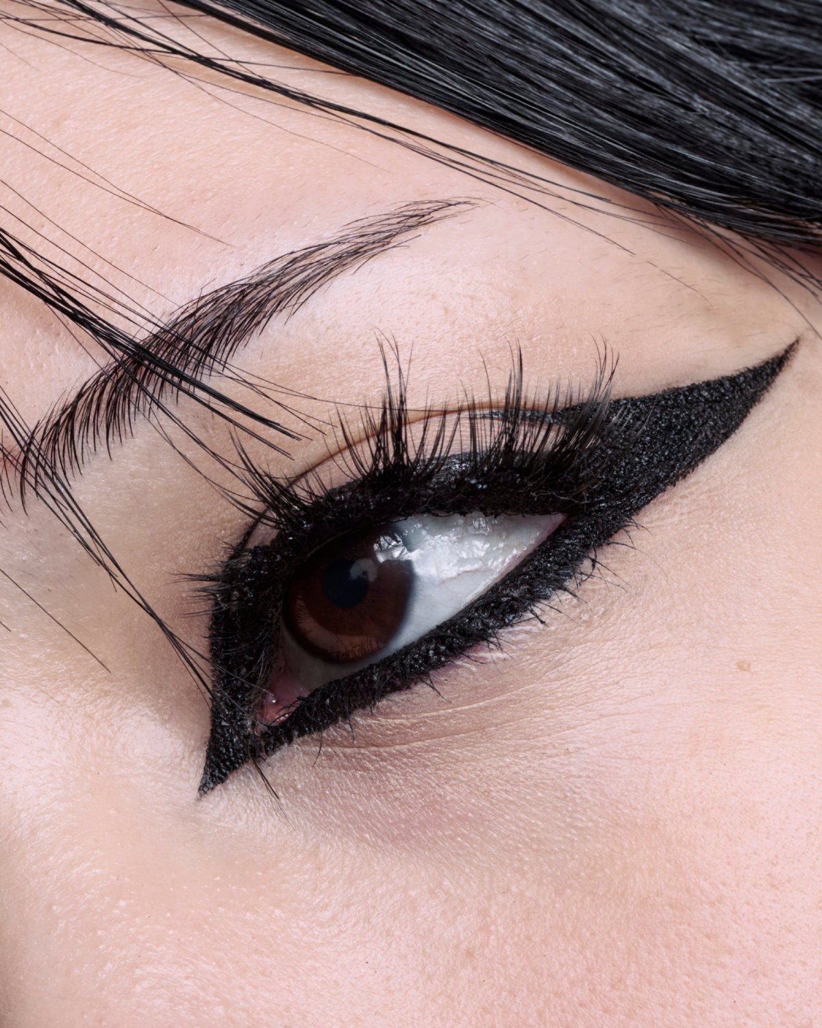 Close-up of an eye with heavy black winged eyeliner and long lashes.