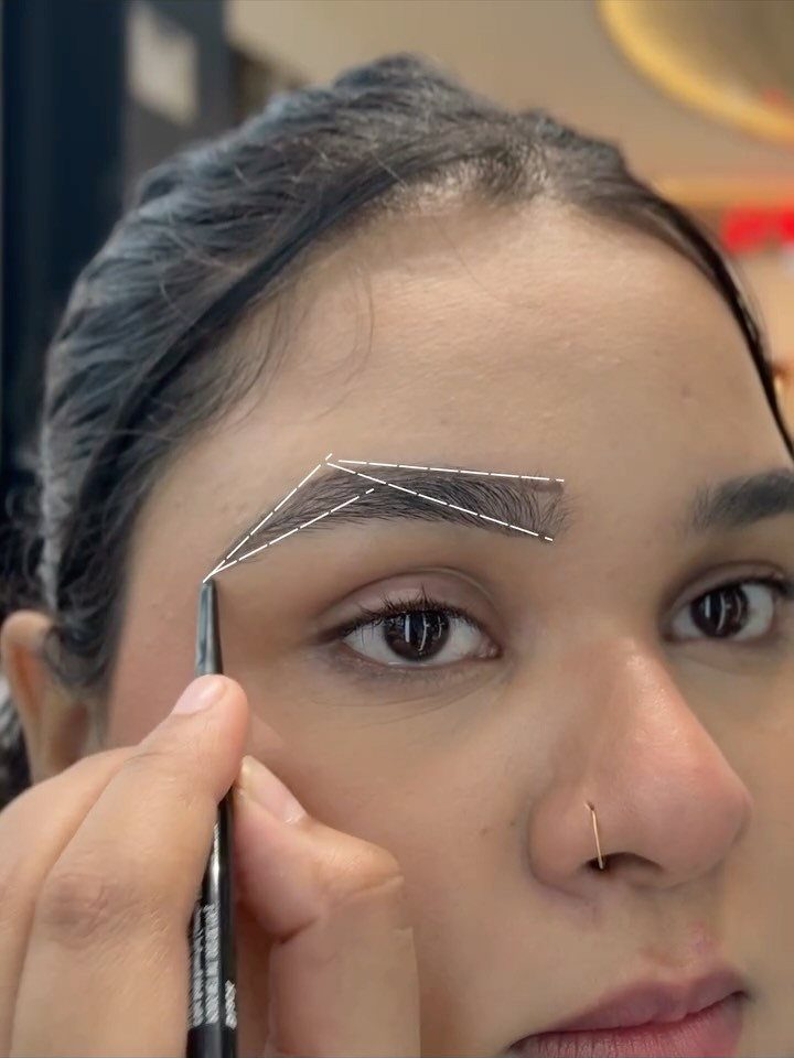 Person receiving an eyebrow shaping treatment with a white string mapping guide.