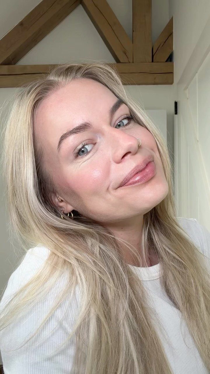 Woman with pale skin and blue eyes wearing a subtle natural makeup look.