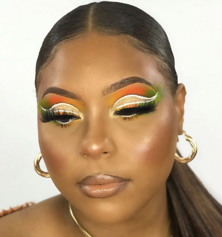 Woman with orange and lime green eyeshadow featuring a sharp white cut crease.