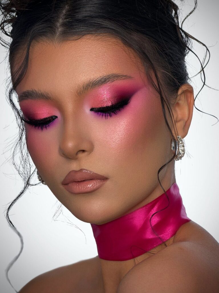 Woman with bold pink and purple eyeshadow and a pink satin choker.