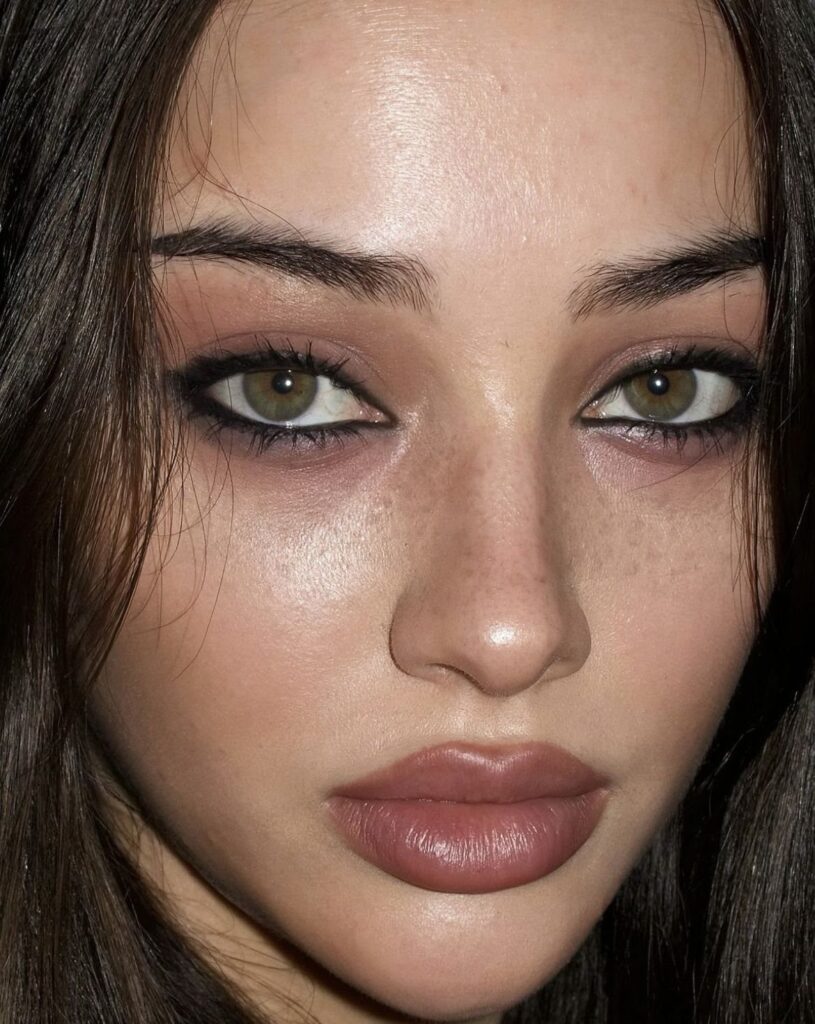 Woman with green eyes wearing reddish-brown eyeshadow and dark eyeliner for a tired look