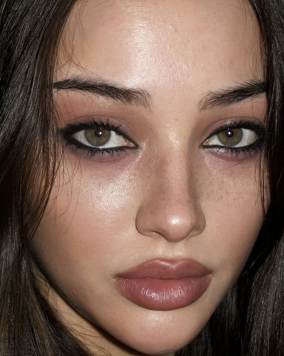 Woman with green eyes wearing reddish-brown eyeshadow and dark eyeliner for a tired look